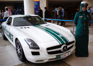 A police officer stands near a Mercedes car used by Dubai police, during the Arabian Travel Market exhibition in Dubai